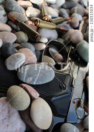 Thrown Out Bullets And Automatic Pistol Under Round Pebbles Vertical Stock Photo Thrown Out Bullets And Automatic Pistol Under Round Pebbles Vertical Stock Photo 130515034