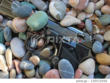 Discarded Automatic Pistol Gun Half Buried In Sea Stones  130515056