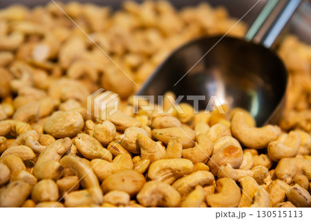 Metal scoop surrounded by raw cashew nuts. Close-up. Background for snacks and nuts Metal scoop surrounded by raw cashew nuts. Close-up. Background for snacks and nuts 130515113