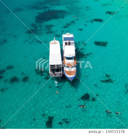 Aerial view of two boats anchoring over turquoise clear water at Racha Island in Phuket, Thailand. Aerial view of two boats anchoring over turquoise clear water at Racha Island in Phuket, Thailand. 130515176
