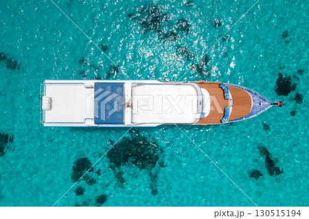 Aerial view of recreational boat over turquoise clear water at Racha Island in Phuket, Thailand. Aerial view of recreational boat over turquoise clear water at Racha Island in Phuket, Thailand. 130515194