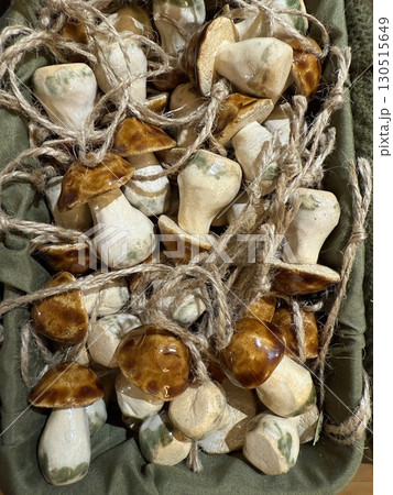 Mushroom ornaments with rustic design tied with twine in brown basket for decorative purposes Mushroom ornaments with rustic design tied with twine in brown basket for decorative purposes 130515649