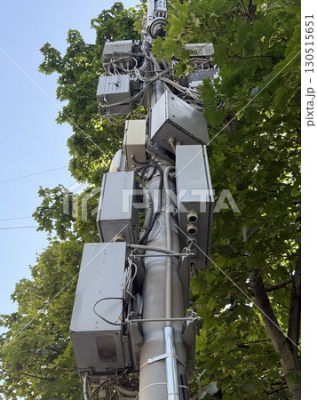 Telecommunication tower surrounded by green foliage against clear blue sky background 130515651