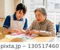 介護施設でレクリエーションを楽しむ高齢者と女性介護士 130517460