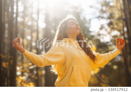 Beautiful woman practices yoga in the autumn forest. Lifestyle and meditation concept. Beautiful woman practices yoga in the autumn forest. Lifestyle and meditation concept. 130517912