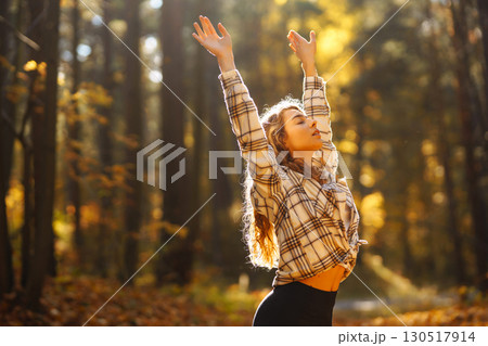 Beautiful woman practices yoga in the autumn forest. Lifestyle and meditation concept. 130517914