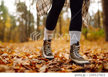 Woman's legs in boots in autumn foliage. Leaf fall. Lifestyle concept. 130517922