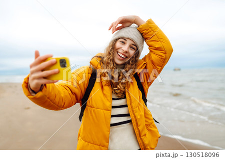 Portrait of a happy woman with a phone on the seashore. Adventure concept, vacation. Portrait of a happy woman with a phone on the seashore. Adventure concept, vacation. 130518096