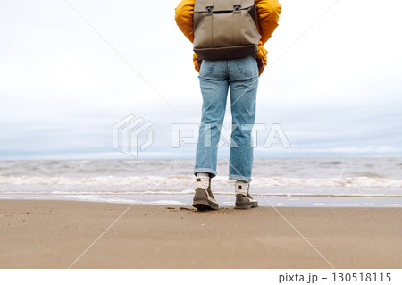 Close-up of woman's legs in boots. Tourist walk along beach near sea. Adventure, vacation concept. Close-up of woman's legs in boots. Tourist walk along beach near sea. Adventure, vacation concept. 130518115