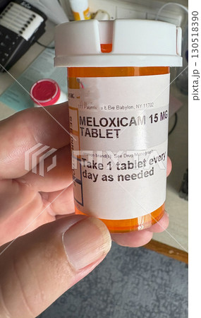 Prescription Bottle for Meloxicam Tablet in a Hand 130518390