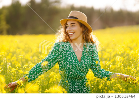 Young woman walking flowering field gently touch yellow flowers. Relax, lifestyle. Summer landscape. Young woman walking flowering field gently touch yellow flowers. Relax, lifestyle. Summer landscape. 130518464