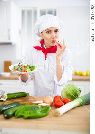 Woman chef holding salad and making bellissimo gesture 130518492