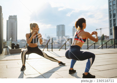 Two Young woman in sports outfit doing exercises outdoors in the morning. Sport, sports training. 130518711