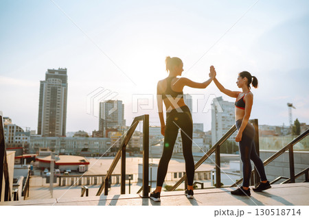 Two Young woman in sports outfit doing exercises outdoors in the morning. Sport, sports training. Two Young woman in sports outfit doing exercises outdoors in the morning. Sport, sports training. 130518714