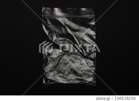 Transparent empty ziplock bag isolated on black background, clear plastic pouch with resealable closure for storage, packaging, organizing, food, travel, and household use. Transparent empty ziplock bag isolated on black background, clear plastic pouch with resealable closure for storage, packaging, organizing, food, travel, and household use. 130519250
