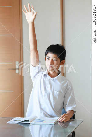 挙手する男子学生 挙手する男子学生 130521817