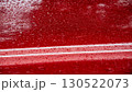 Raindrops on a vibrant red surface, showing a blurred reflection of surroundings and highlighting the beauty of nature's elements 130522073