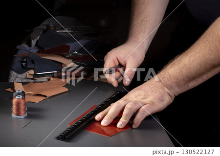 The process of making leather goods. The hands of the master work with a leather product. 130522127