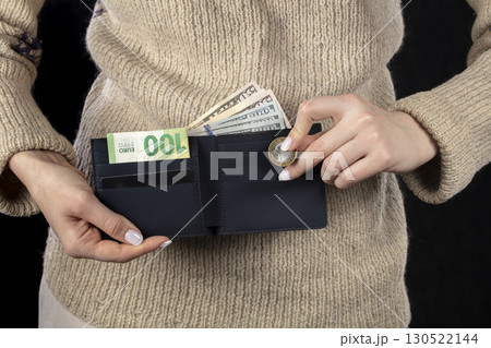 In female hands, a brown wallet with euros and dollars. In female hands, a brown wallet with euros and dollars. 130522144