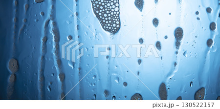 Water drops with foam on glass on a blue background. Water drops with foam on glass on a blue background. 130522157