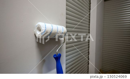 Clean paint roller leaning against wall near garage door Clean paint roller leaning against wall near garage door 130524069