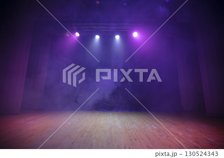 A stage for performances with purple curtains, wood floor and all in smoke. Theatrical background. 130524343