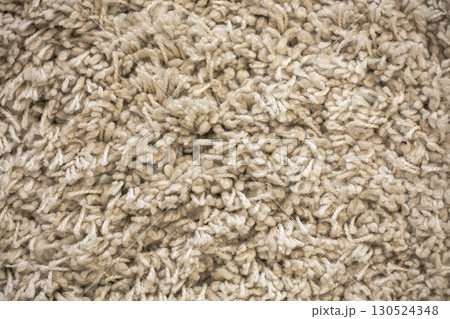 The texture of a beige long-pile carpet. 130524348