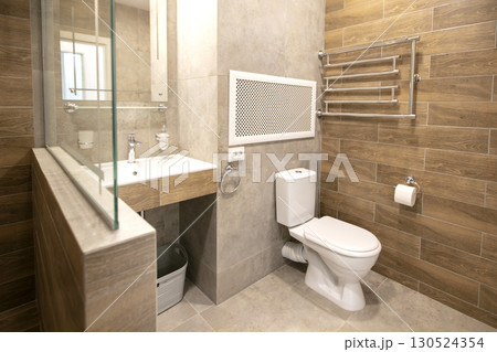 Toilet room interior with beige ceramic tiles. 130524354
