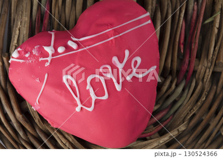 A beautiful pink gingerbread or heart-shaped cookie with the word "love" written on it. Sweet edible valentine's day gift. 130524366