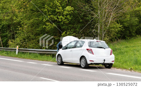 Broken car with open hood on the side of the highway 130525072
