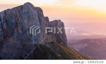 Drone shot of Bolshoy Tkhach rocky dramatic mount in Caucasus with sunset or sunrise tones 130525110