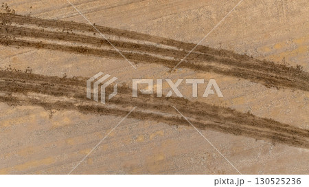 Aerial top view tire track on dirt sand mud, Texture of wet mud road with puddle and Tyre or tire track in countryside, Wheel tyre or tire track on mud, texture and background. 130525236