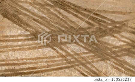 Aerial top view tire track on dirt sand mud, Texture of wet mud road with puddle and Tyre or tire track in countryside, Wheel tyre or tire track on mud, texture and background. 130525237