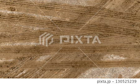 Aerial top view tire track on dirt sand mud, Texture of wet mud road with puddle and Tyre or tire track in countryside, Wheel tyre or tire track on mud, texture and background. 130525239