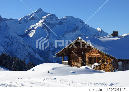 Snow covered Oldenhorn and facade of a old farmhouse, winte rscene near Gstaad, Switzerland. Snow covered Oldenhorn and facade of a old farmhouse, winte rscene near Gstaad, Switzerland. 130526145