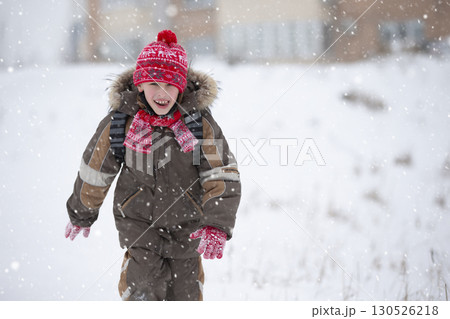 Funny boy in winter goes to school with a backpack. 130526218