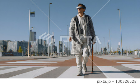 A visually impaired person confidently walking in the city with a smart AI cane. Ideal for inclusive tech, accessibility, and social equality themes. 130526328