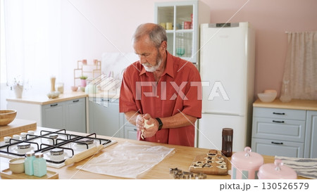 Senior man kneading dough, baking in modern kitchen 130526579