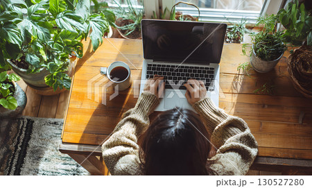 Freelancer working remotely from home with a relaxed and productive setup top view. Ideal for blogs, tech services, and work-from-home promotions. 130527280