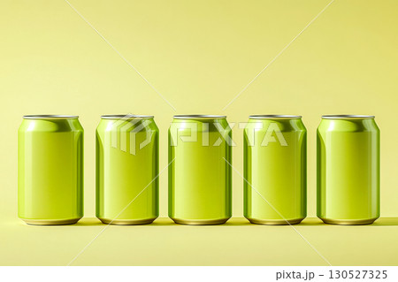 Five green cans are lined up on a yellow surface, casting soft shadows. Concept of minimalism and color contrast. For beverage advertising. 130527325
