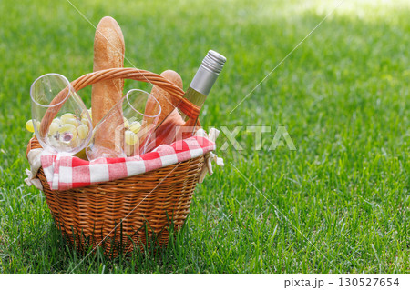 Picnic basket with wine, grapes, and baguette 130527654