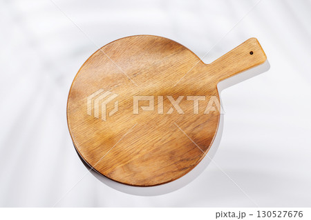 Empty cutting board on a white background with leaf shadows 130527676