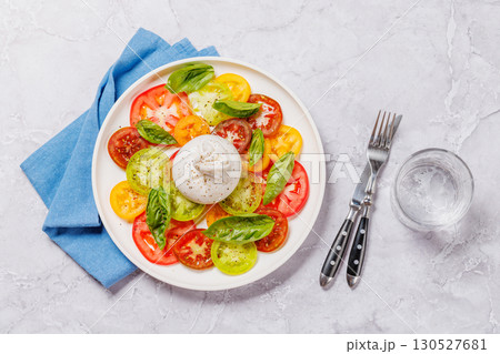 Fresh burrata served on slices of colorful tomatoes Fresh burrata served on slices of colorful tomatoes 130527681