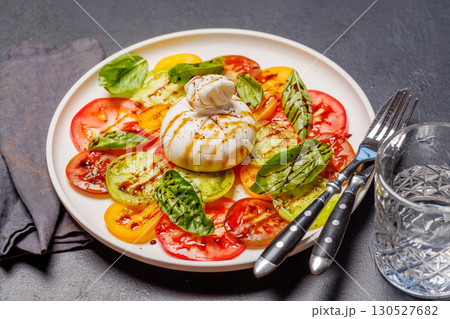 Fresh burrata served on slices of colorful tomatoes Fresh burrata served on slices of colorful tomatoes 130527682