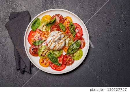 Fresh burrata served on slices of colorful tomatoes Fresh burrata served on slices of colorful tomatoes 130527797