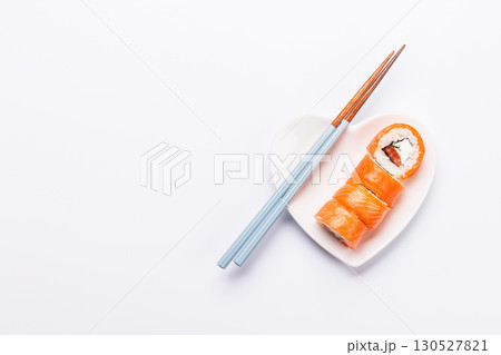 A heart-shaped plate filled with delicious sushi, accompanied by chopsticks 130527821