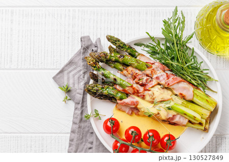 Grilled asparagus with bacon and egg sauce 130527849