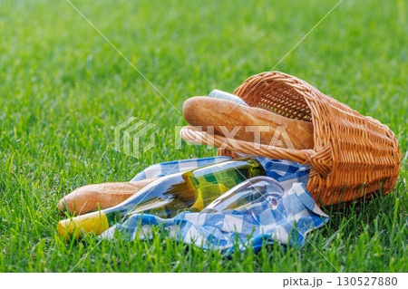 Picnic basket with wine, grapes, and baguette 130527880