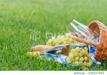 Picnic basket with wine, grapes, and baguette 130527881
