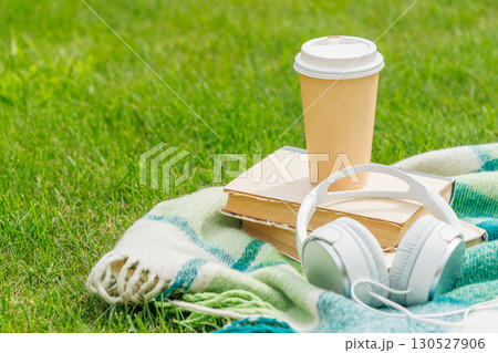 Books, coffee, and headphones on a sunny lawn Books, coffee, and headphones on a sunny lawn 130527906
